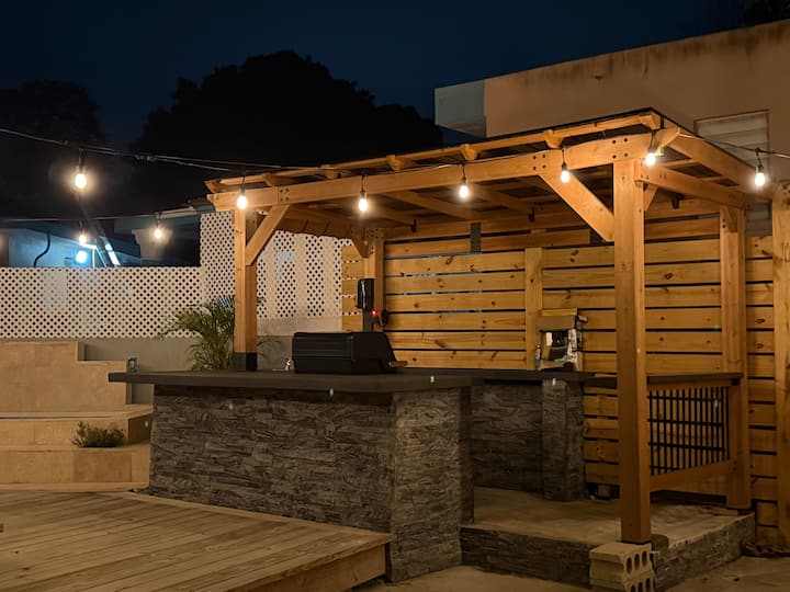 Outdoor bar and grill pergola with string lights